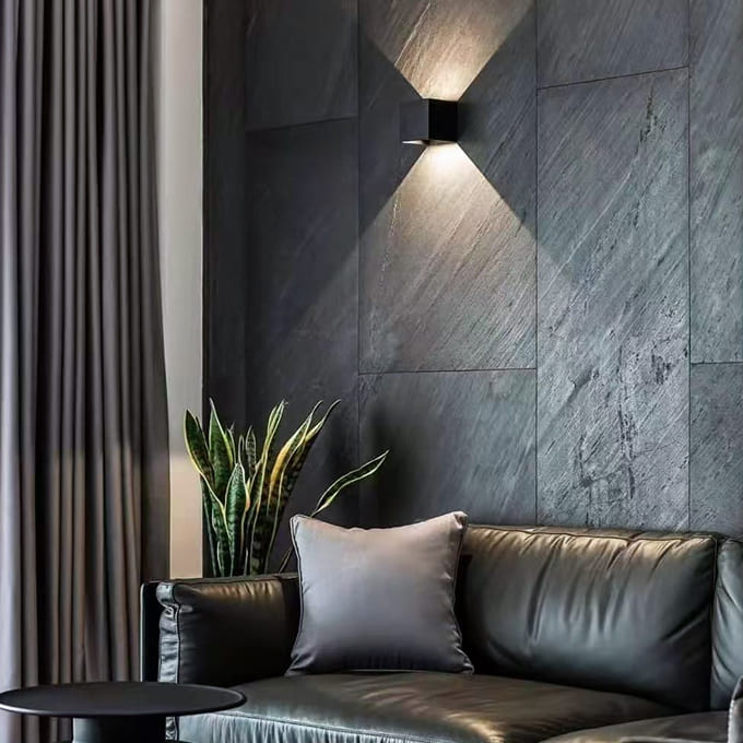 Mantra grey slate stone veneer accent wall behind a leather living room sofa.